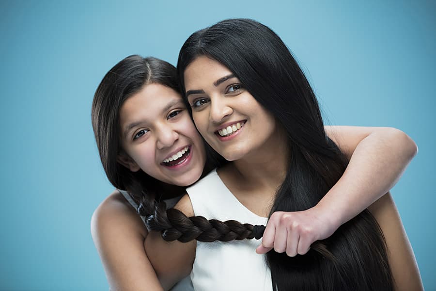 Happy mother-daughter with healthy and long hair